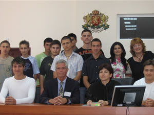 Judge Ken Stuart, Director of the USAID JSI (seated, center), joins Targovishte judges and students following a mock trial at the JSI Regional Grantee Exhibition