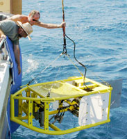 Kevin O’Toole (top) and Hank Chezar (wearing hat) recover the camera sled onboard the research vessel Ocean Sentinel