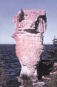 Photo showing layers of sedimentary rock eroded by wind and wave action revealed in formations at Flower Pot Island at tip of the Bruce Peninsula in Canada