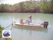 photo of scientists in boat equipped with Acoustic Doppler Flow Measurement instrument, includes inset image of instrument