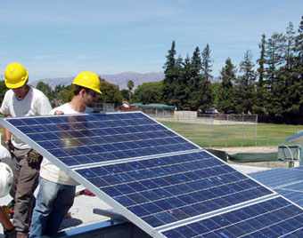 Workers install a solar panel