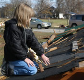 profile of girl holding plastic horse on the destroyed roof of her grandmother's home