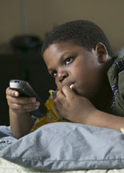 photo of child watching TV and eating