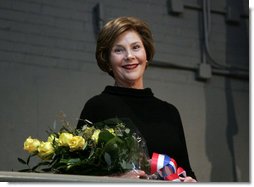 Mrs. Laura Bush stands with a bouquet presented along with the Department of Defense Outstanding Public Service Award by U.S. Secretary of Defense Robert Gates during a military appreciation Tuesday, Jan. 6, 2009, in honor of President George W. Bush's tenure as Commander-in-Chief.  White House photo by Joyce N. Boghosian