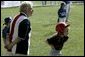 A runner with the Hamilton Little Lads of Hamilton, N.J., waits to make her next move with her honorary base coach Dolly White, former fielder with the Fort Wayne Daises and the Kenosha Comets, during the last game of the 2003 White House South Lawn Tee Ball season Sunday, Sept. 7, 2003. Ms. White played professional baseball with the All-American Girls Professional Baseball League Players Association, which operated from 1943 to 1954. White House photo by Lynden Steele.