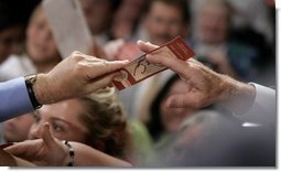 President George W. Bush returns a ticket to an audience member after signing it following his remarks on CAFTA-DR in Dallas, N.C., Friday, July 15, 2005.  White House photo by Eric Draper