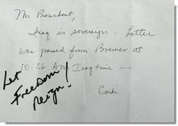 President George W. Bush receives confirmation of Iraqi sovereignty, then wrote, “Let Freedom Reign!,” during the opening session of the NATO Summit in Istanbul, Turkey, Monday, June 28, 2004.   White House photo by Eric Draper