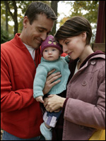 Photo: Parents holding a baby.