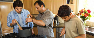 Photo: A father and sons preparing a meal.