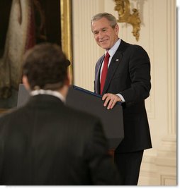 President George W. Bush smiles as he responds to a writer's question Wednesday, Feb. 14, 2007, during a press conference in the East Room of the White House. The President covered many topics including international issues and bipartisan opportunities. White House photo by Eric Draper