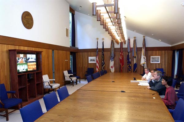 President George W. Bush meets with his National Security advisors via video conference at Camp David, Saturday, Sept. 22, 2001. Also pictured from left, White House Chief of Staff Andy Card, CIA Director George Tenent and National Security Advisor Condoleezza Rice. White House photo by Eric Draper.