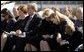 Joining the family of Space Shuttle Columbia Commander Rick Husband, President George W. Bush and Laura Bush bow their heads in prayer during a memorial service at NASA's Lyndon B. Johnson Space Center Tuesday, Feb. 4, 2003. Sitting with the President are Mr. Husband's wife, Evelyn, and children Laura and Matthew. White House photo by Paul Morse