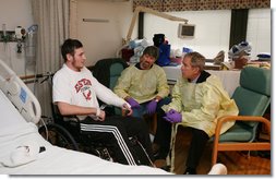 President George W. Bush sits and visits with U.S. Marine Lance Cpl. Michael Stilson of Clarkson, W. Va., and his father, Robert Stilson, at the National Naval Medical Center in Bethesda, Md., Wednesday, Dec. 19, 2007. Stilson is recovering from injuries sustained in Operation Iraqi Freedom. White House photo by Joyce N. Boghosian