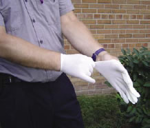 Fotografía de un trabajador mientras se pone guantes de látex