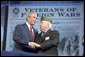 President George W. Bush talks with Veterans of Foreign Wars Commander-in-chief John Furgess during his visit to the VFW national convention in Salt Lake City, Utah, August 22, 2005. White House photo by Paul Morse