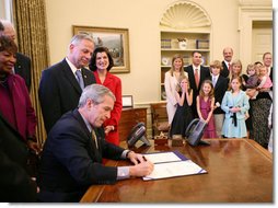 President George W. Bush, joined by the family of former President Lyndon Baines Johnson, signs H.R. 584 designating the U.S. Department of Education in Washington, D.C., as the Lyndon Baines Johnson Federal Building, Friday, March 23, 2007 in the Oval Office. White House photo by Eric Draper