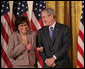 President George W. Bush stands with Volunteer Service Award recipient Maria Hines of Albuquerque, N.M., in the East Room of the White House, Friday, Oct. 7, 2005, where President Bush honored six recipients of the President's Volunteer Service Awards, as part of the celebration of Hispanic Heritage Month. White House photo by Eric Draper