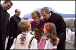 President George W. Bush and Laura Bush are greeted by children at the airport in Bucharest, Romania Saturday, Nov. 23, 2002. White House photo by Susan Sterner.