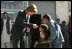 Laura Bush hands red, white and blue kaleidoscopes to youngsters outside a Kabul bakery Wednesday, March 30, 2005 during her visit to Afghanistan. 