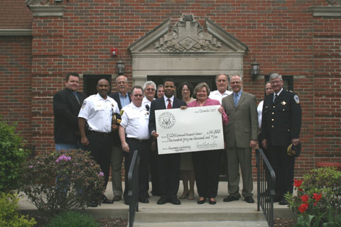 Congressman Jackson with representatives of E-Com Dispatch Center and community representatives, holding up giant check for $141,000 for technology upgrades