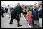 Greeted by flowers and smiles, President George W. Bush returns the gesture during his and Laura Bush's arrival in Maastricht, Netherlands, May 7, 2005. White House photo by Eric Draper