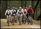 President George W. Bush rides with the Travis Air Force Base cycling team in the Los Posados State Forest, in Angwin, California, Saturday, April 22, 2006. White House photo by Eric Draper