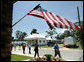 President George W. Bush waves as he is joined by Biloxi Mayor A.J. Holloway, left, Monday, Aug. 28, 2006, during President Bush’s walking tour in the same Biloxi, Miss., neighborhood he visited following Hurricane Katrina in September 2005. The tour allowed President Bush the opportunity to assess the progress of the area’s recovery and rebuilding efforts following the devastating hurricane. White House photo by Eric Draper