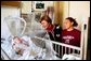 Laura Bush visits with 4-month-old Devon Garner and his mother Tracy Garner at the Children's National Medical Center in Washington, D.C., Friday, Dec. 12, 2003. Mrs. Bush attended the hospital's annual Christmas program.  White House photo by Susan Sterner