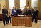 President George W. Bush signs H. R. 2297, the Veterans Benefits Act of 2003, in the Oval Office Tuesday, Dec. 16, 2003. The act expands the benefits program for veterans and their surviving spouses. In attendance are, from left: veterans Dave Thornton of Haymarket, Va.; Charles Stenger of Bethesda, Md.; Carol Near of East Moline, Ill.; Congressman Rob Simmons, R-Conn.; Congressman Chris Smith, R-N.J.; Congressman Lane Evans, D-Ill.; Congressman Henry Brown, R-S.C.; Congressman Bob Filner, D-Calif.; and veteran Guillermo Rumingan of Arlington, Va.  White House photo by Paul Morse