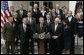 Flanked by members of the Cabinet, President George W. Bush delivers remarks to the media during a press conference Tuesday, March 28, 2006, in the Rose Garden of the White House. White House photo by Paul Morse