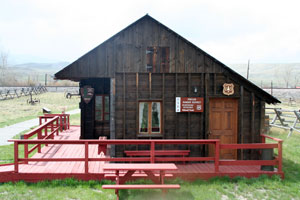 photo of a wooden building with a red porch/deck around the outside.