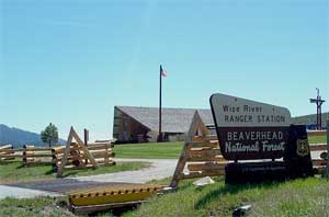 [photo] Approach to the ranger station - shows the driveway, sign, flag, and building.