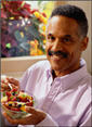 Man eating a bowl of fruit