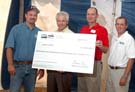 Mr. Dorr holds the ceremonial check to Amana Farms