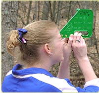 student measuring tree height