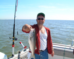 Photo of man holding up fish he caught