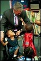 During a tour of Highland Park Elementary School in Landover, Md., President George W. Bush plays with children at the school's Head Start Center where he discussed strengthening America's Head Start Program Monday, July 7, 2003.  White House photo by Paul Morse