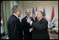 President George W. Bush shakes hands with Iraqi President Jalal Talabani, right, during his visit Tuesday, June 13, 2006, to the U.S. Embassy in Baghdad. With them is U.S. Ambassador to Iraq Zalmay Khalilzad.  White House photo by Eric Draper