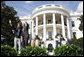 President George W. Bush is joined by Colombian musician Andres Cabas as they wave to invited guests, following Cabas and his band's performance Thursday, Oct. 9, 2008 on the South Lawn of the White House, during the celebration of Hispanic Heritage Month.  White House photo by Eric Draper