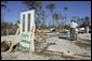 President George W. Bush stands with Al Boyd in the ruins of where Boyd's home used to be during a walking tour of neighborhoods damaged by Hurricane Ivan in Pensacola, Florida, Sunday, Sept. 19, 2004.  White House photo by Eric Draper