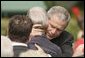 President George W. Bush embraces one of the hundreds of family and friends who gathered on the South Lawn of the White House, Friday, Sept. 9, 2005, during the 9/11 Heroes Medal of Valor Award Ceremony, in honor of the courage and commitment of emergency services personnel who died on Sept. 11, 2001.  White House photo by Paul Morse