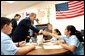 President George W. Bush visits with art students at the Association for the Advancement of Mexican Amercians Headquarters Summer Enrichment Camp in Houston, Texas, Friday, June 14. Also pictured at left, is Texas Gov. Rick Perry.  