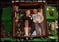 President George W. Bush talks with assembly worker Deborah Davis after starting up a combine with a gold-plated ignition key at John Deere Harvester Works in East Moline, Ill., Monday, Jan. 14, 2002. "I'm confident in the American farmer," said the President, addressing about 1500 employees and supporters. "I know the American farmer is more efficient, and can raise more crop than anybody, anywhere in the world." White House photo by Eric Draper.