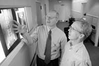 Dr. Michael Ward (l) a rheumatologist with NIAMS, shows CC patient Christian Drobnyk his X-rays and the places on his spine affected by ankylosing spondylitis.