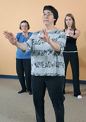 Women perform a tai chi exercise.