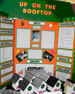 Photo: science project with display board and models of houses.