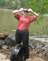 Cleanup crew member with an abandoned tire and a dead fish.