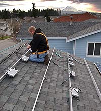 man on roof working on electrical fixtures