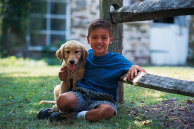 young boy hugging a dog