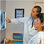 two people in lab coats looking at an X-ray